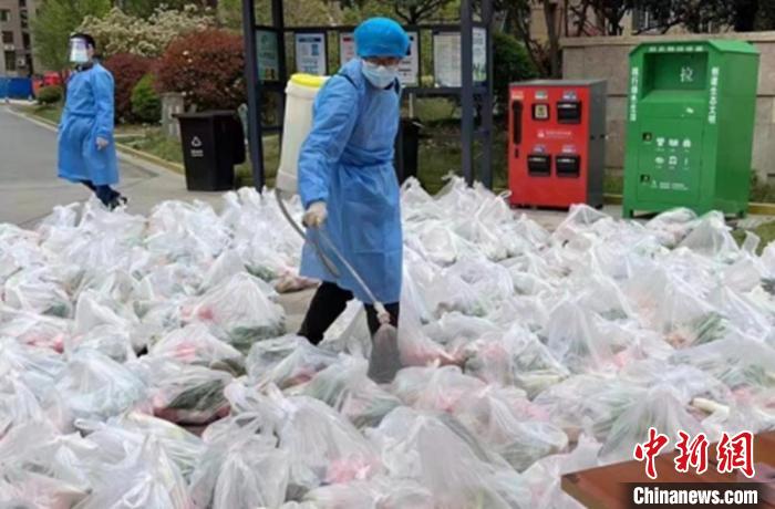 睢宁恒华新都汇小区志愿者为即将发放的蔬菜包消毒。睢宁县委宣传部供图