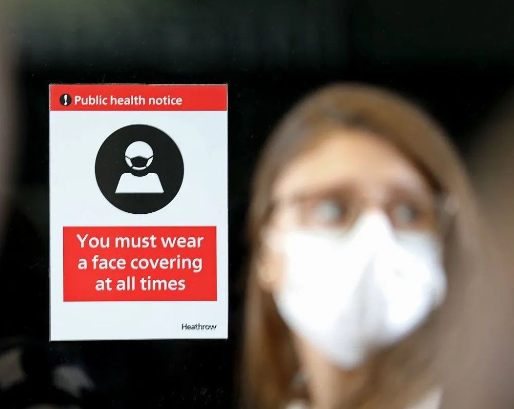 3月18日，一名女子经过英国伦敦希思罗机场内的防疫告示。图源：新华社