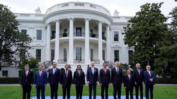 图片说明：12日，美国总统拜登（中）与参加美国-东盟峰会的东盟国家领导人在白宫南草坪合影。（美联社）