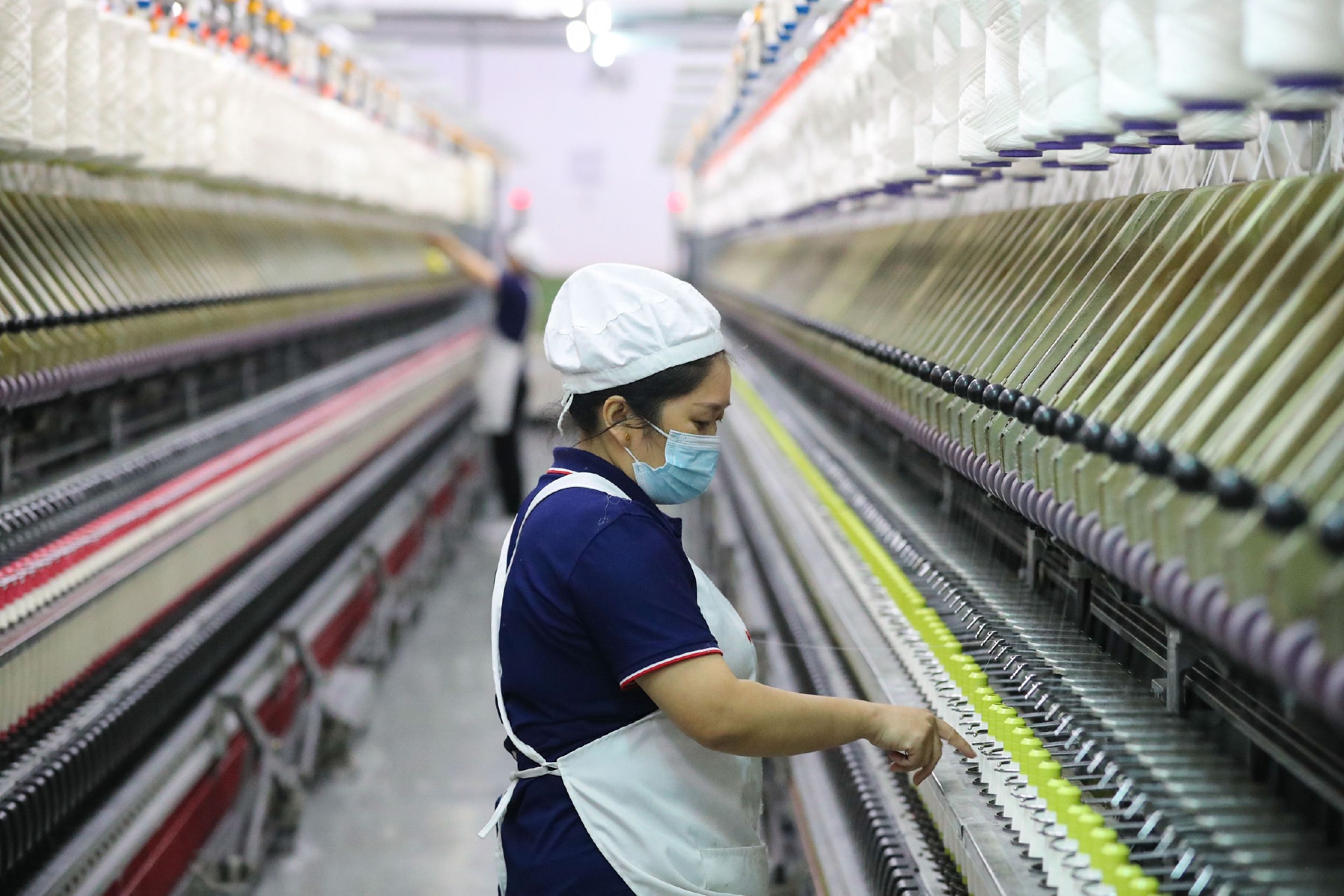 2022年11月25日，浙江湖州，德清县钟管镇南舍工业园区的一家纺织企业，工人在生产车间工作。 视觉中国 图