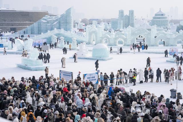 游客在哈尔滨冰雪大世界园区排队，等待体验超级冰滑梯（1月1日摄）。 新华社 图