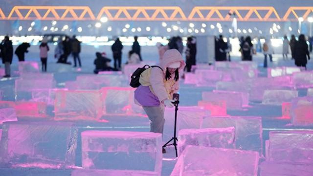 游客在哈尔滨松花江冰雪嘉年华景区的“冰光秀场”游玩、拍照（1月3日摄）。 新华社 图