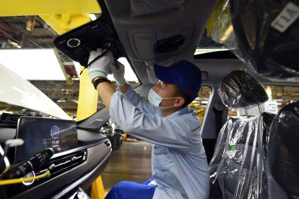 图说：5月20日，在位于安徽省芜湖市的奇瑞汽车股份有限公司，工人在总装三车间忙碌。 新华社发（周牧摄）