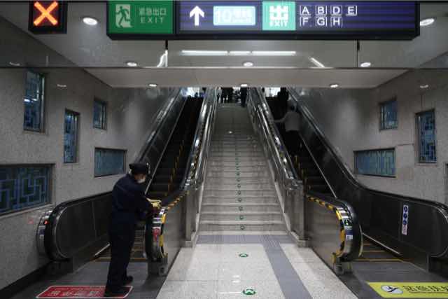 5月12日，北京地铁7号线双井站，保洁人员对电梯扶手进行擦拭消毒。中国日报记者 邹红 摄