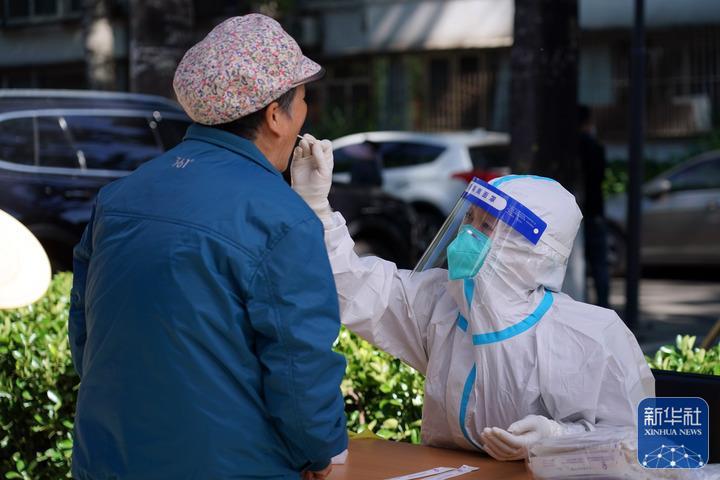 ↑5月13日，在北京市海淀区八里庄街道首师大社区的一处临时核酸检测采样点，医护人员进行核酸采样。新华社记者 任超 摄