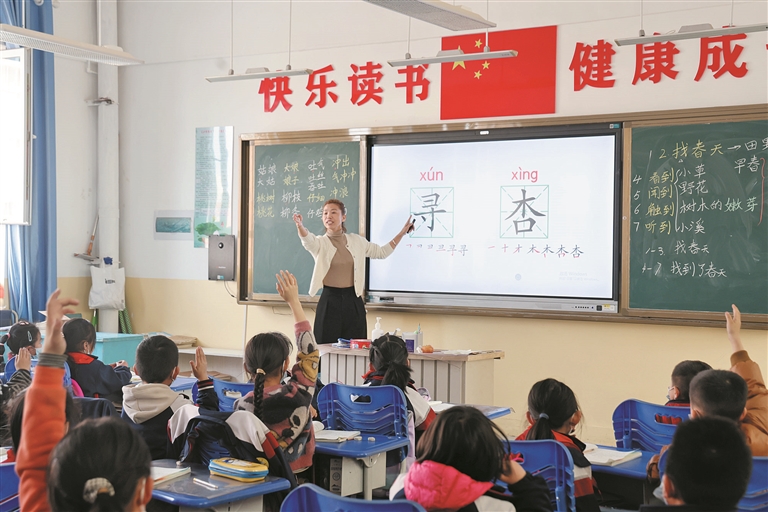4月19日，一师十六团中学教师在用生动有趣的方式引导二年级（1）班学生认字。 张涛 摄