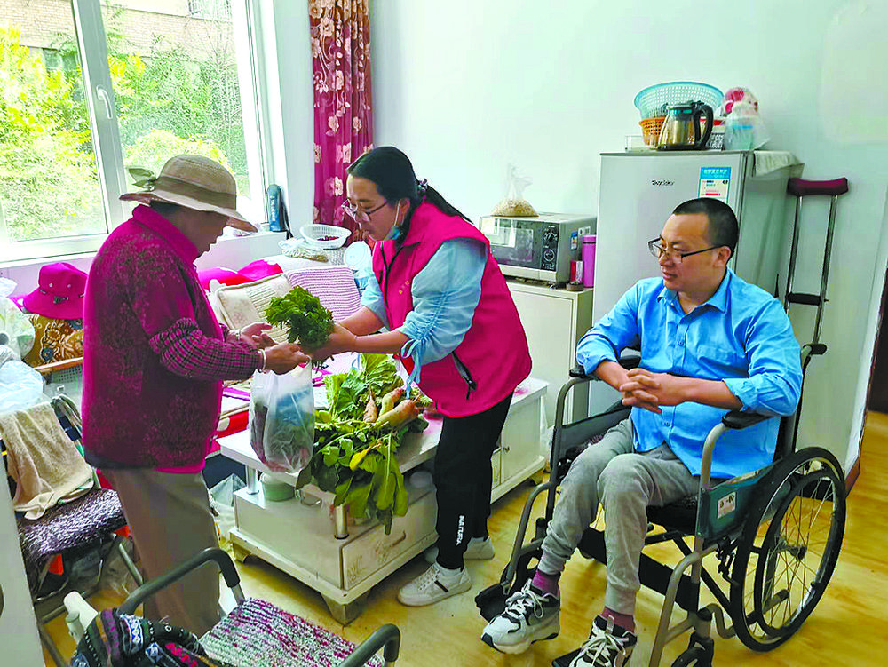 志愿者将“爱心菜园”收获的新鲜蔬菜第一时间送给辖区困难群众。资料图片