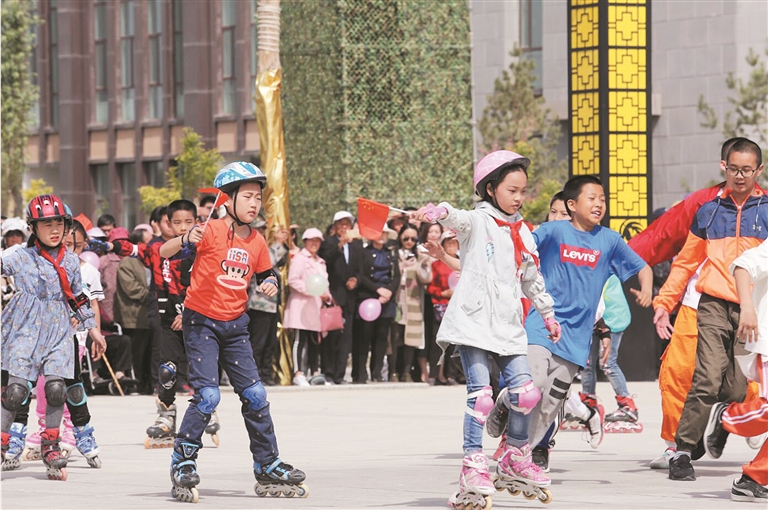二师铁门关市丝路雄关广场上，孩子们在进行滑轮表演（摄于4月23日）。李嘉成 摄