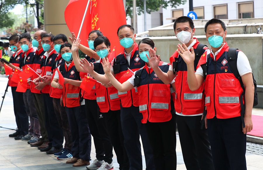 5月27日，福建省援沪医疗队队员向送行人员挥手道别。 中国日报记者 朱兴鑫 摄