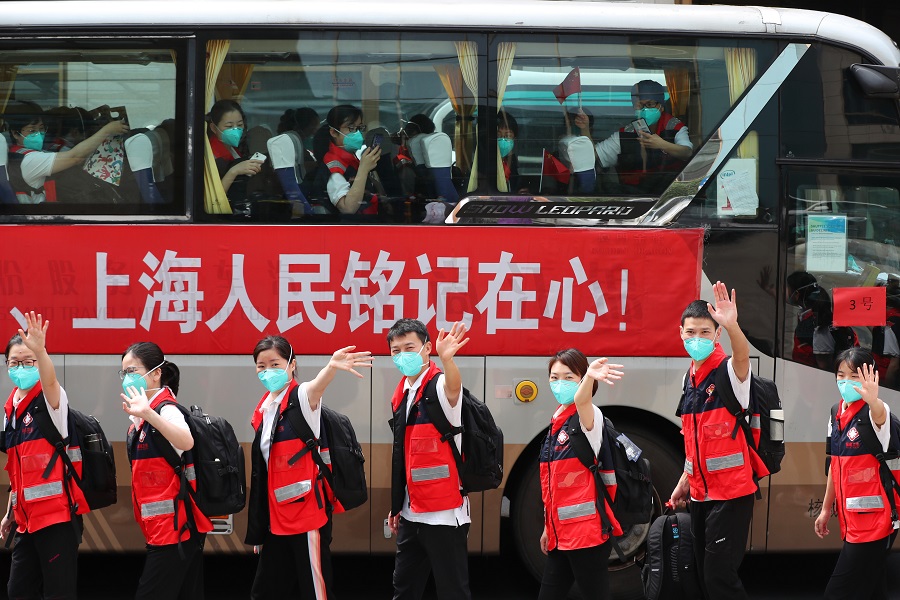 5月27日，福建省援沪医疗队队员准备乘坐大巴向送行人员挥手道别。 中国日报记者 朱兴鑫 摄