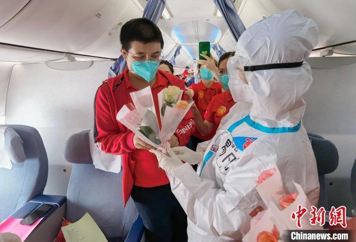 南航乘务人员向每一位医疗队员赠予鲜花。张瞳 摄