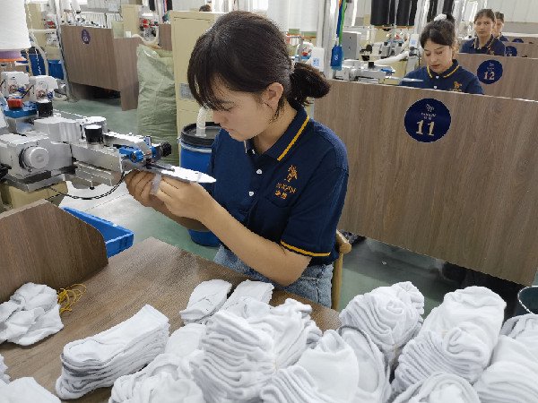  图为新疆唐锦纺织有限公司生产车间内工人在工作中。