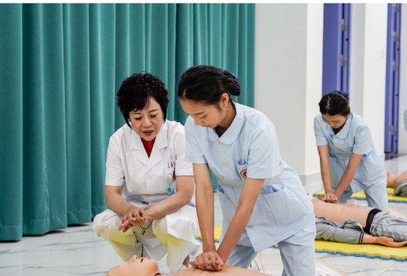 张先庚（左一）在护理实训室指导学生做急救操作。 李汶瑾 摄