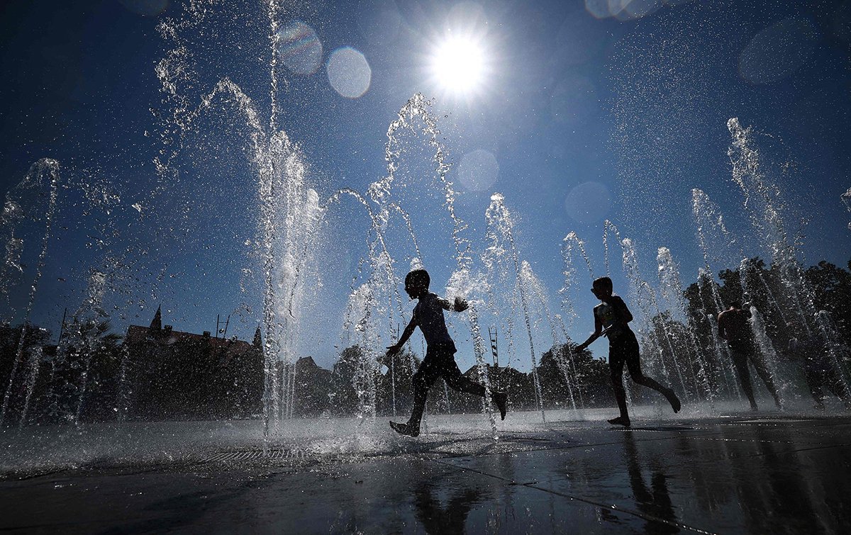 当地时间2023年8月21日，法国东部科尔马，孩子们在公共喷泉中奔跑，为自己降温，法国正在经历夏末的热浪。