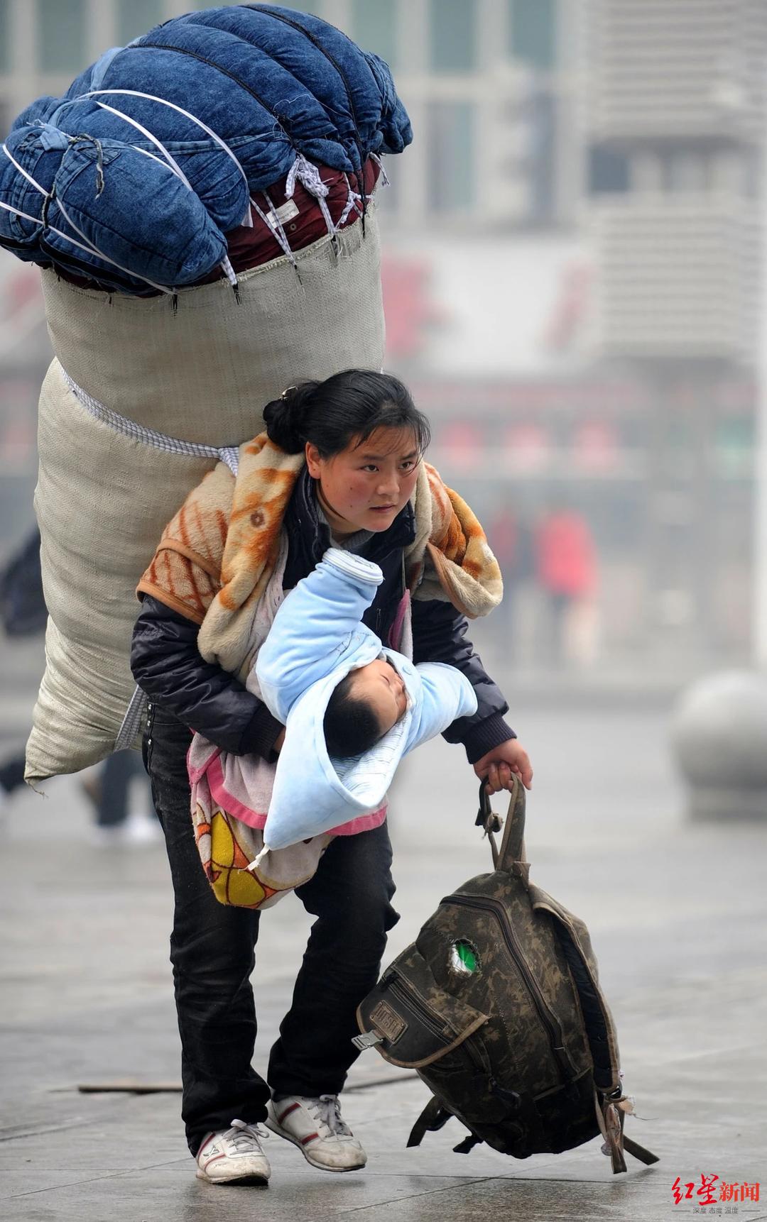 ▲2010年1月30日，巴木玉布木背着大包、抱着孩子在南昌火车站匆忙赶车 周科 摄