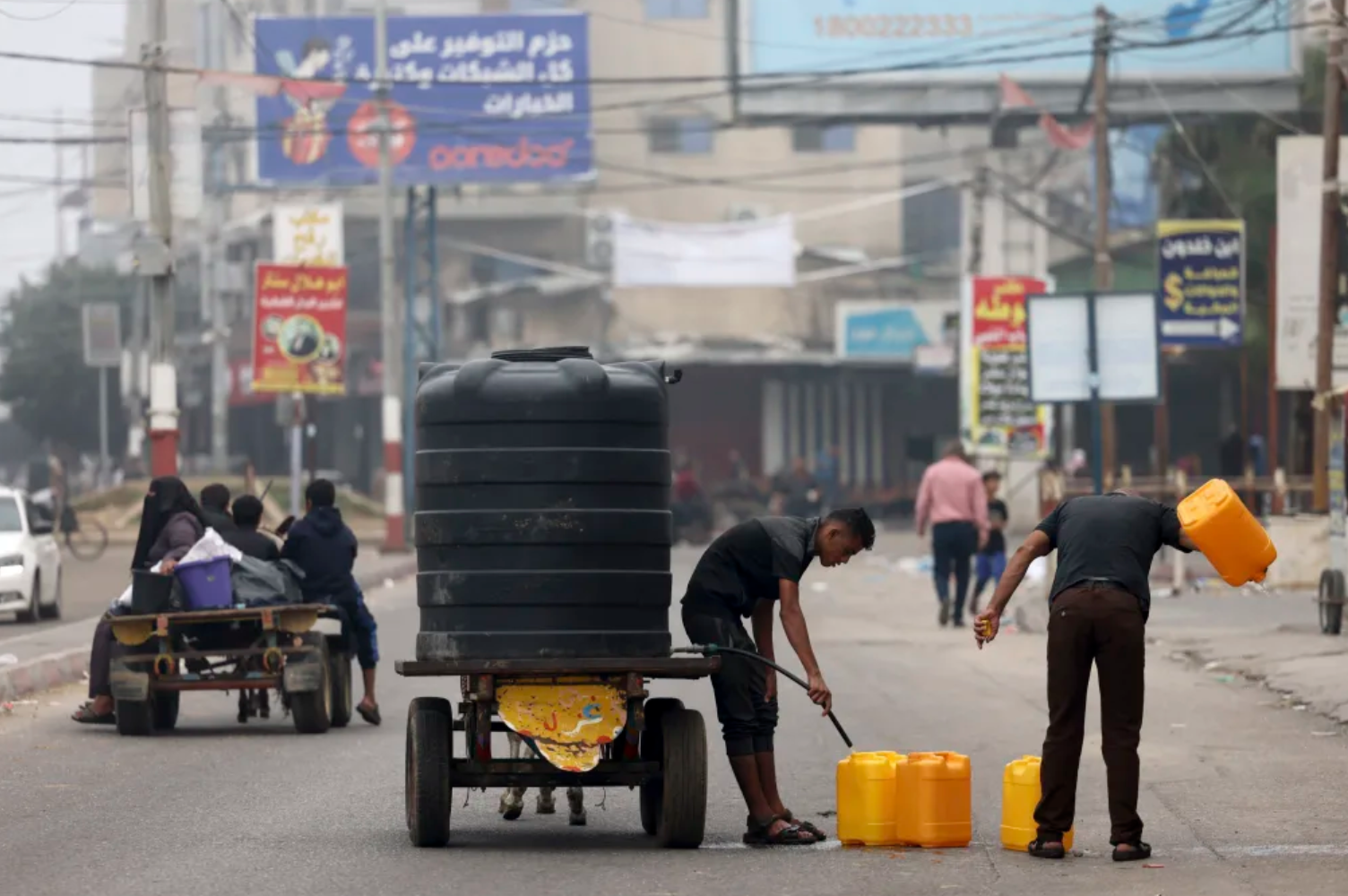 ▲加沙平民用塑料桶装水回家