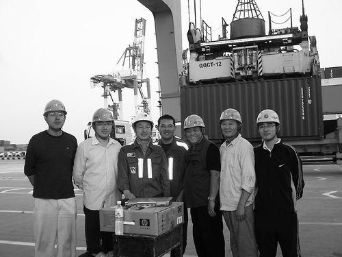 ▲2007年，张凯临（左二）和许振超（左三）等人在桥吊项目现场。