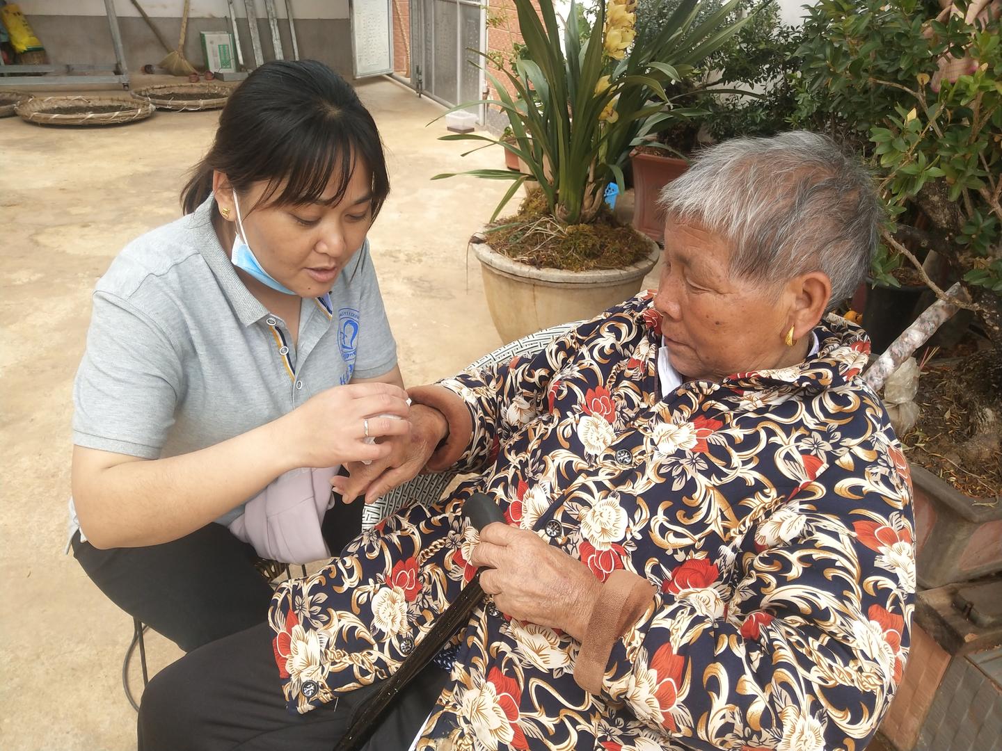 ▲在去看望老人的时候，杨建媛（左）常常会帮老人理头发、剪指甲