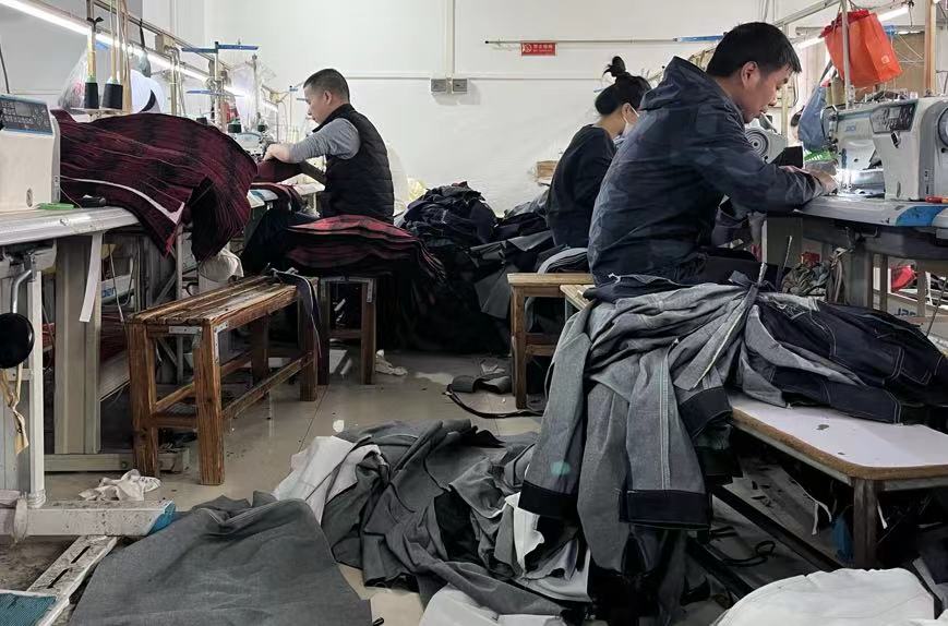 制衣工人们在工厂做工。 时代财经/摄
