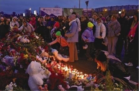 3月23日，在俄罗斯莫斯科近郊，人们在恐袭事件发生地附近摆放鲜花和蜡烛悼念遇难者。