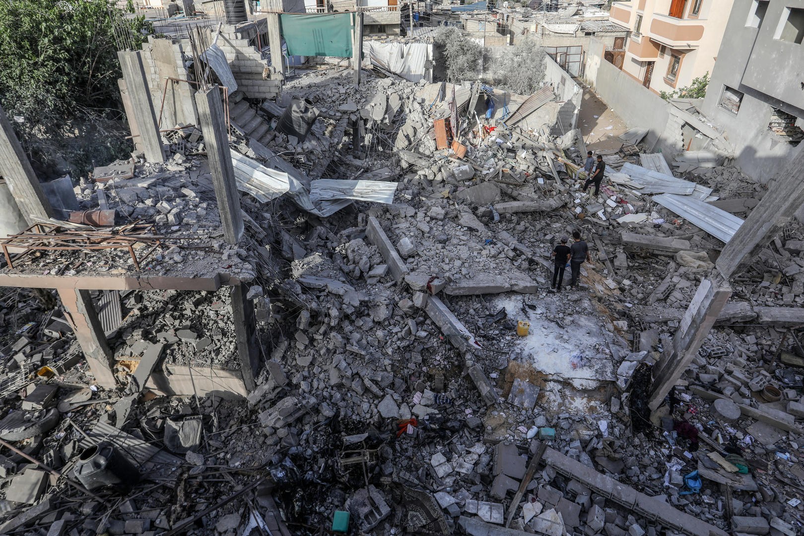 ▲24日，以色列袭击后，巴勒斯坦居民在废墟中检查被摧毁的建筑物