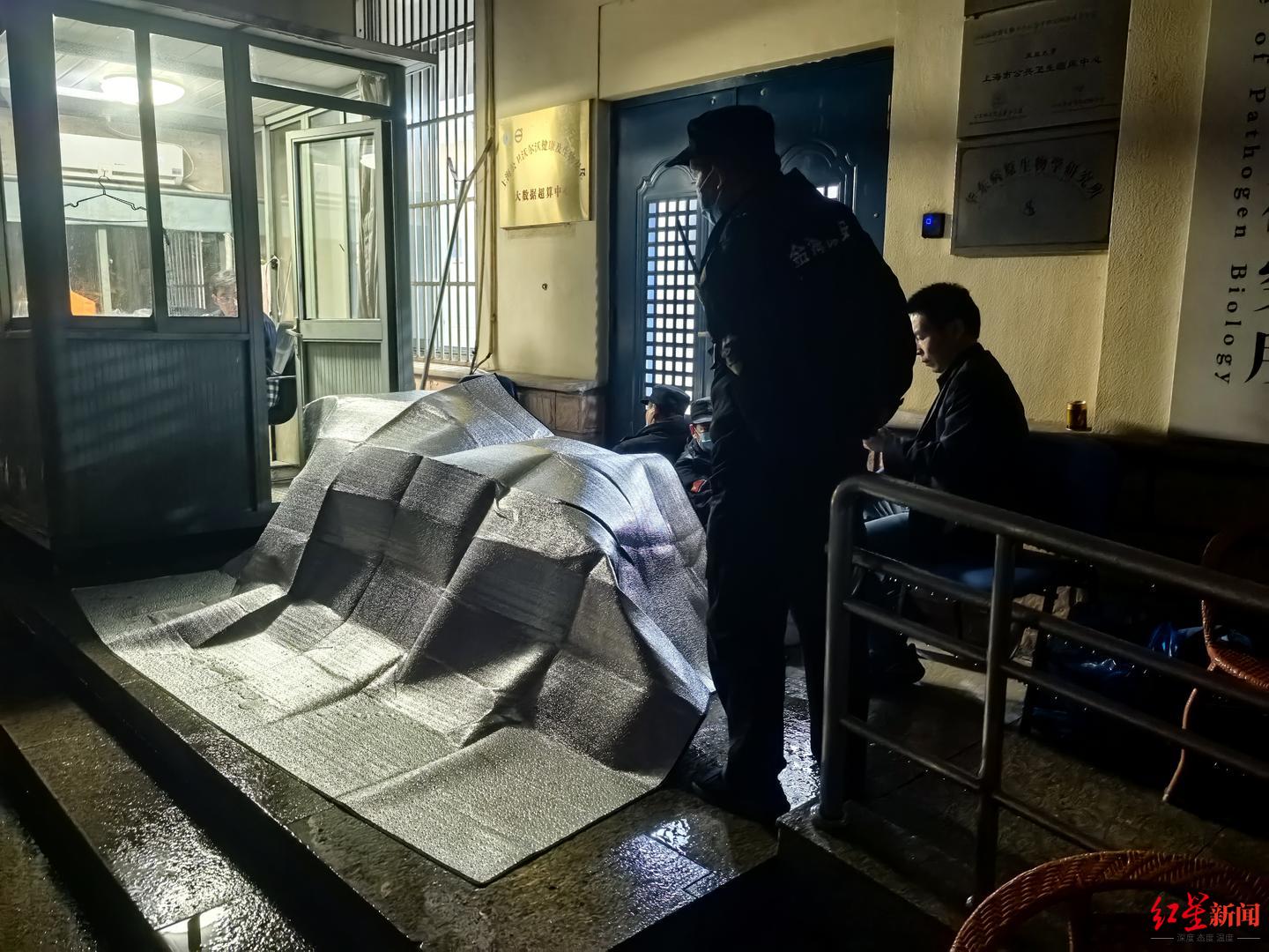 28日晚，上海公卫中心，中雨，张永振用伞和保温材料搭起来挡雨。受访者供图
