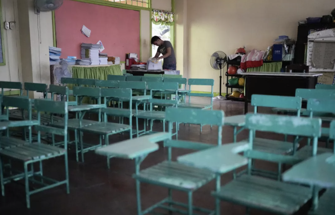▲由于高温天气，菲律宾取消了线下课程。图为一名老师在空荡的教室里整理桌子